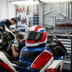 Illustration for our Honda story: a helmet rests on the fuel tank of a MotoGP bike in a garage.