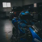 A racing helmet and gloves sit on a Yamaha MotoGP bike in the pit garage, symbolising a rider's retirement.