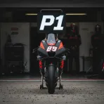 A MotoGP bike parked under a 'P1' board in the pit box after qualifying.
