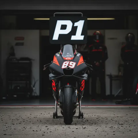 A MotoGP bike parked under a 'P1' board in the pit box after qualifying.