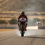 A MotoGP rider celebrates crossing the finish line to win the Aragon Grand Prix.
