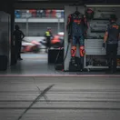 An empty garage space in the MotoGP pits, representing a rider's absence due to injury.