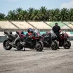 Illustration for our Indonesian Grand Prix story: four racing motorcycles parked in a row in the pit lane enclosure.