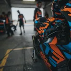 Maverick Viñales sits alone on a pit wall, looking thoughtful after a practice session.