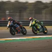 Two MotoGP riders locked in a close battle on the final corner of a race, illustrating a fierce rivalry.
