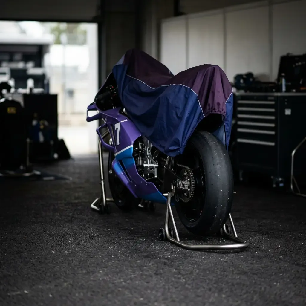 Illustration for our rider injury story: a covered racing motorbike on paddock stands in a pit garage.