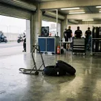 Illustration for our rider injury story: an empty garage bay with paddock equipment and bike stands.