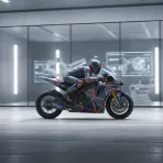 A brand new, unpainted Yamaha MotoGP bike in a workshop, with a technician applying Jorge Martin's race number to it.